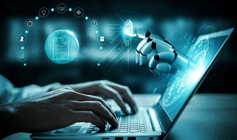 Agentic AI - Image with someone working on a laptop and a robot hand pointing out of the screen